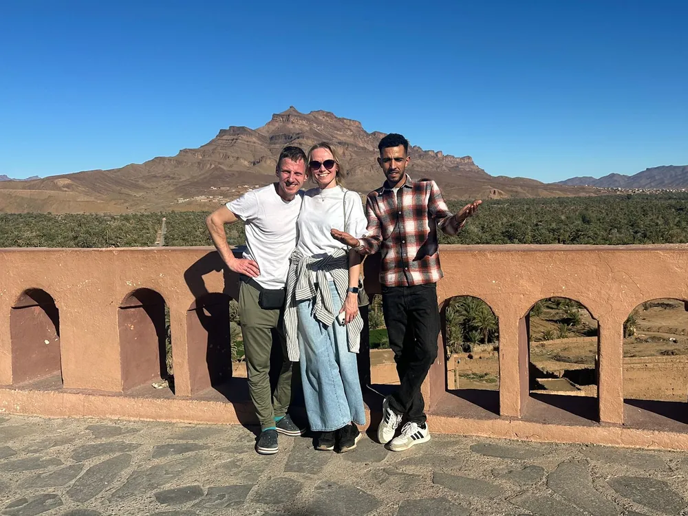 Travelers with their driver-guide above the Draa Valley on an 8-day Morocco tour from Marrakech